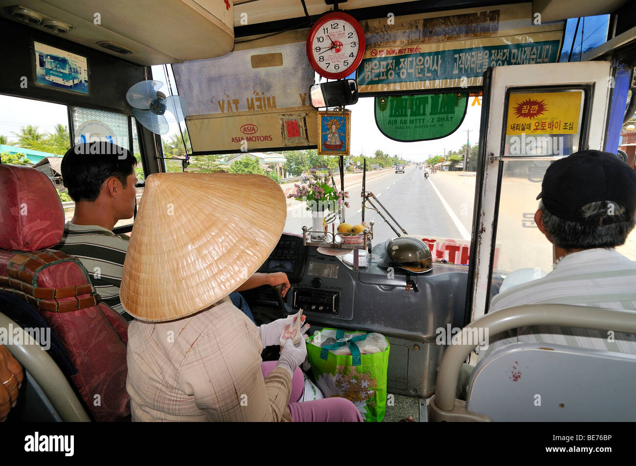 Driver, passenger and cashier looking from a minibus onto the road, Mekong Delta, Vietnam, Southeast Asia Stock Photo