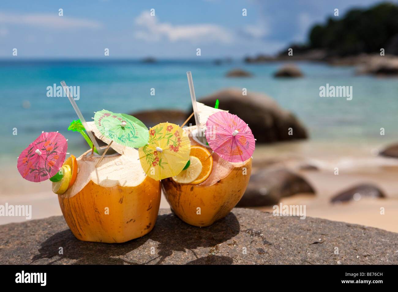 Two decorated coconuts filled with drinks standing on a granite rock, island Mahe, Seychelles, Indian Ocean, Africa Stock Photo