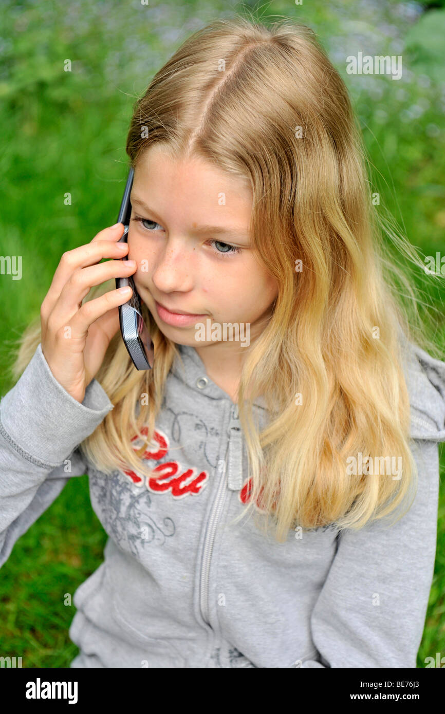 9-year-old girl talking on a mobile phone, cellphone Stock Photo