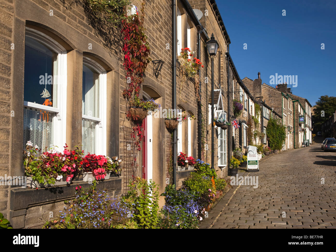 UK, England, Yorkshire, Haworth, Main Street, houses with floral planting outside Stock Photo