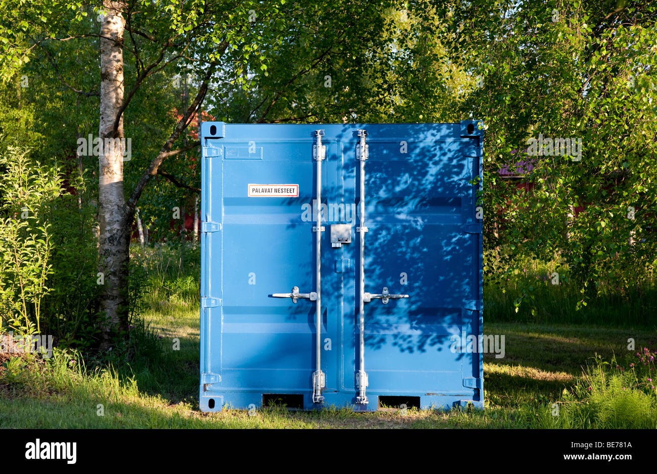 Blue metallic shipping container in the forest , Finland Stock Photo