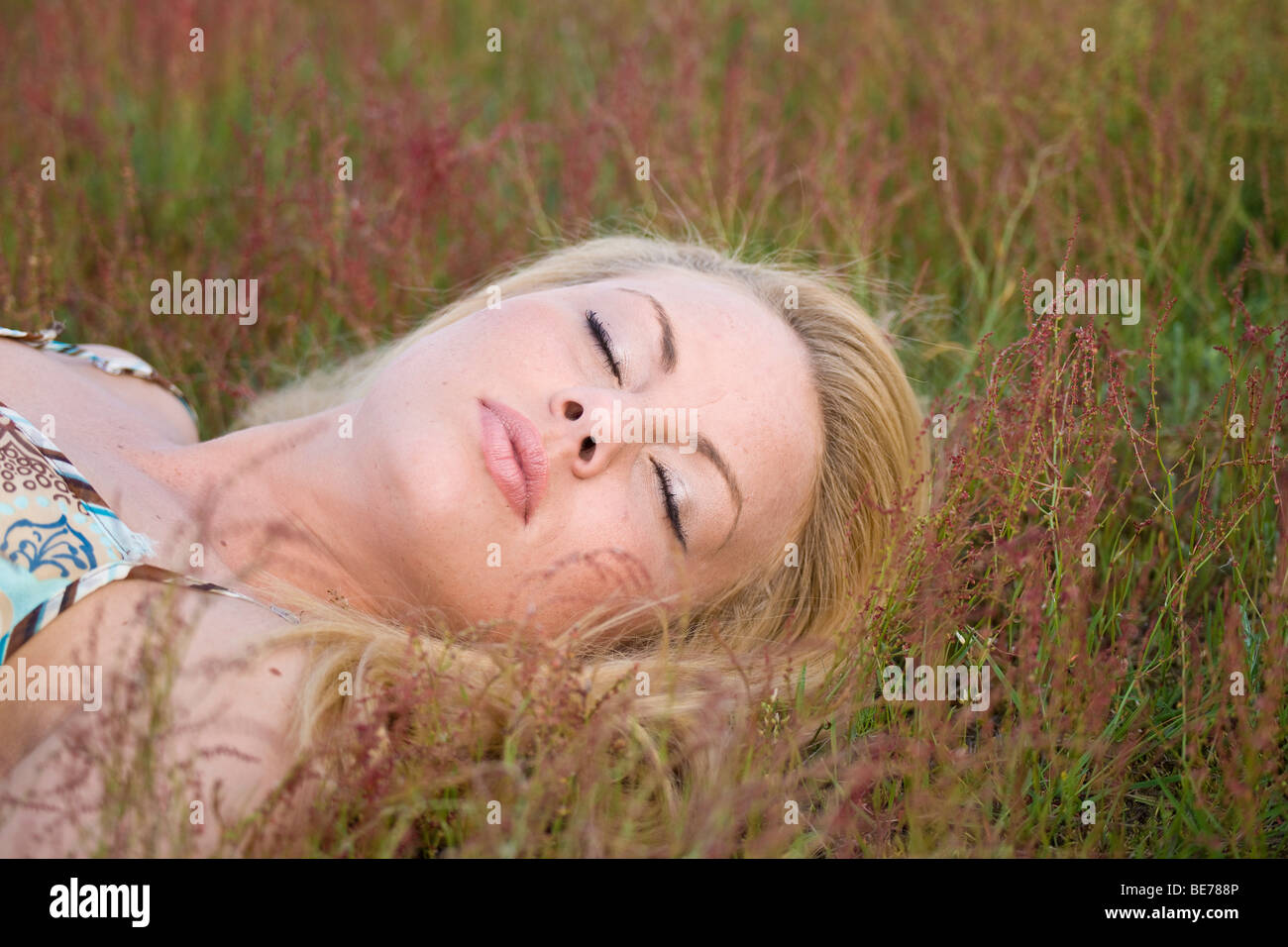 Young blonde woman sleeping on a meadow Stock Photo