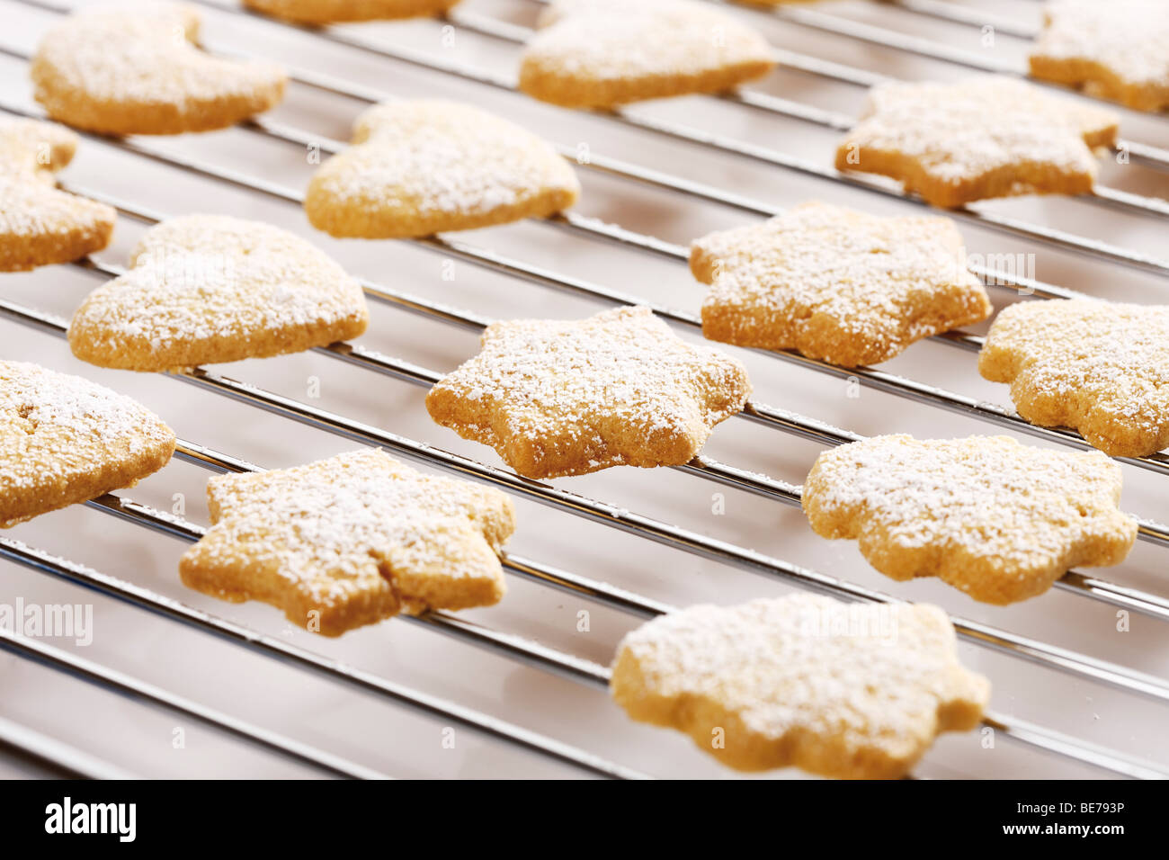 Shortcrust cookies on oven grid, dusted with powdered sugar Stock Photo