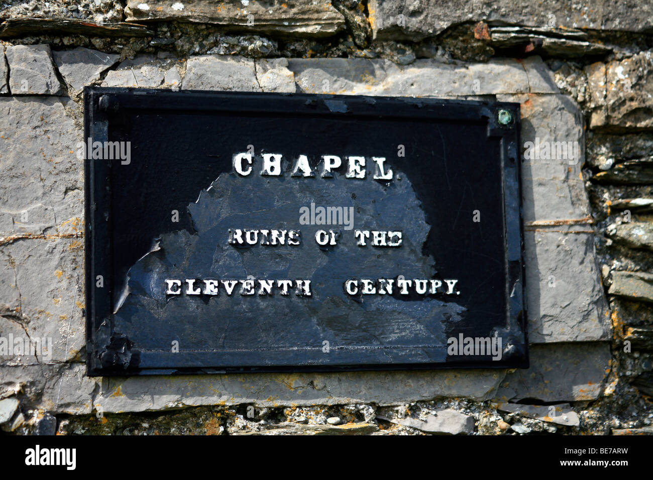Black metal plaque with white lettering on an eleventh century chapel Stock Photo