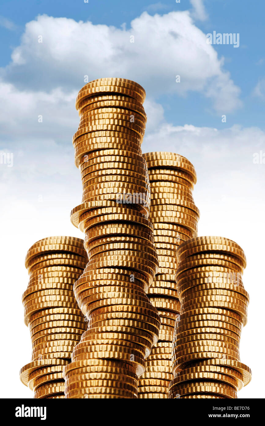 Money stacks in front of a blue sky Stock Photo