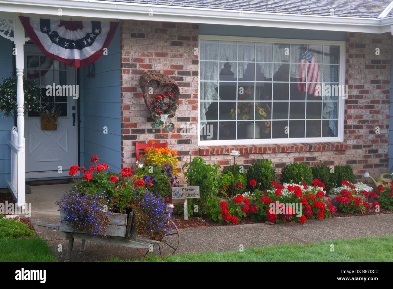 A homeowner displays the red, white, and blue patriotic theme. Stock Photo