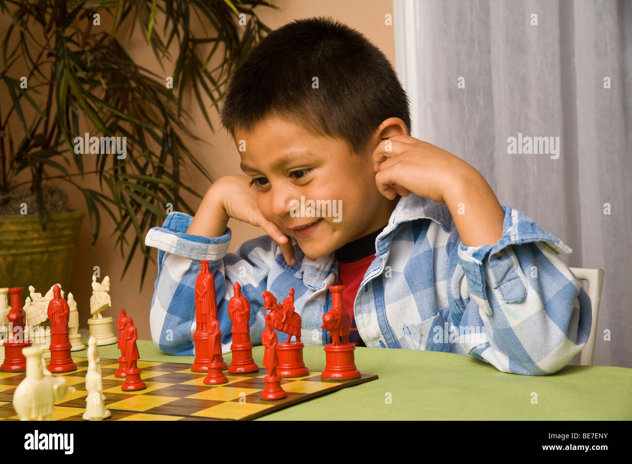 7-8 year old Hispanic boy learning to play chess. MR  © Myrleen Pearson Stock Photo