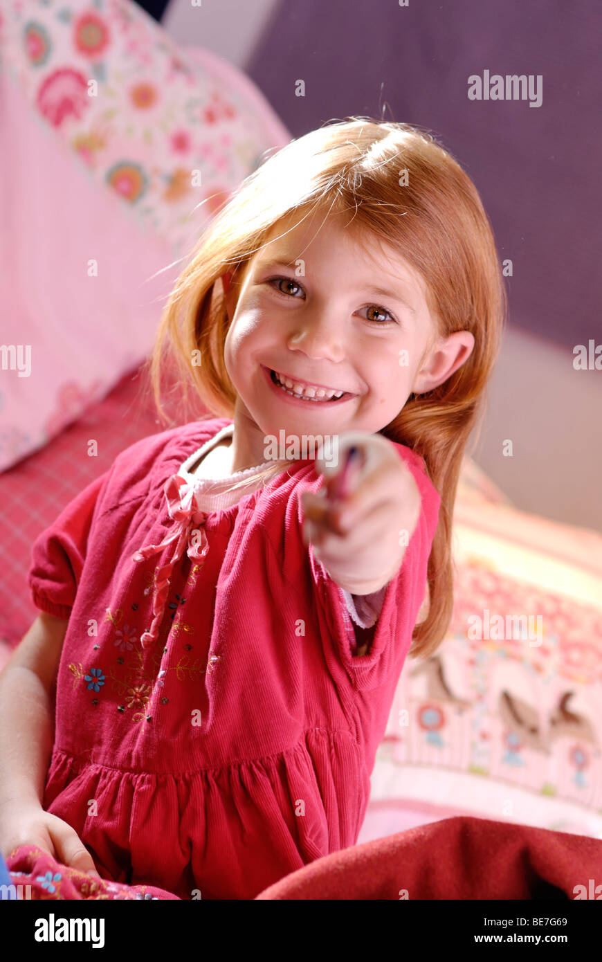 Little girl holding a pen in her hand Stock Photo - Alamy