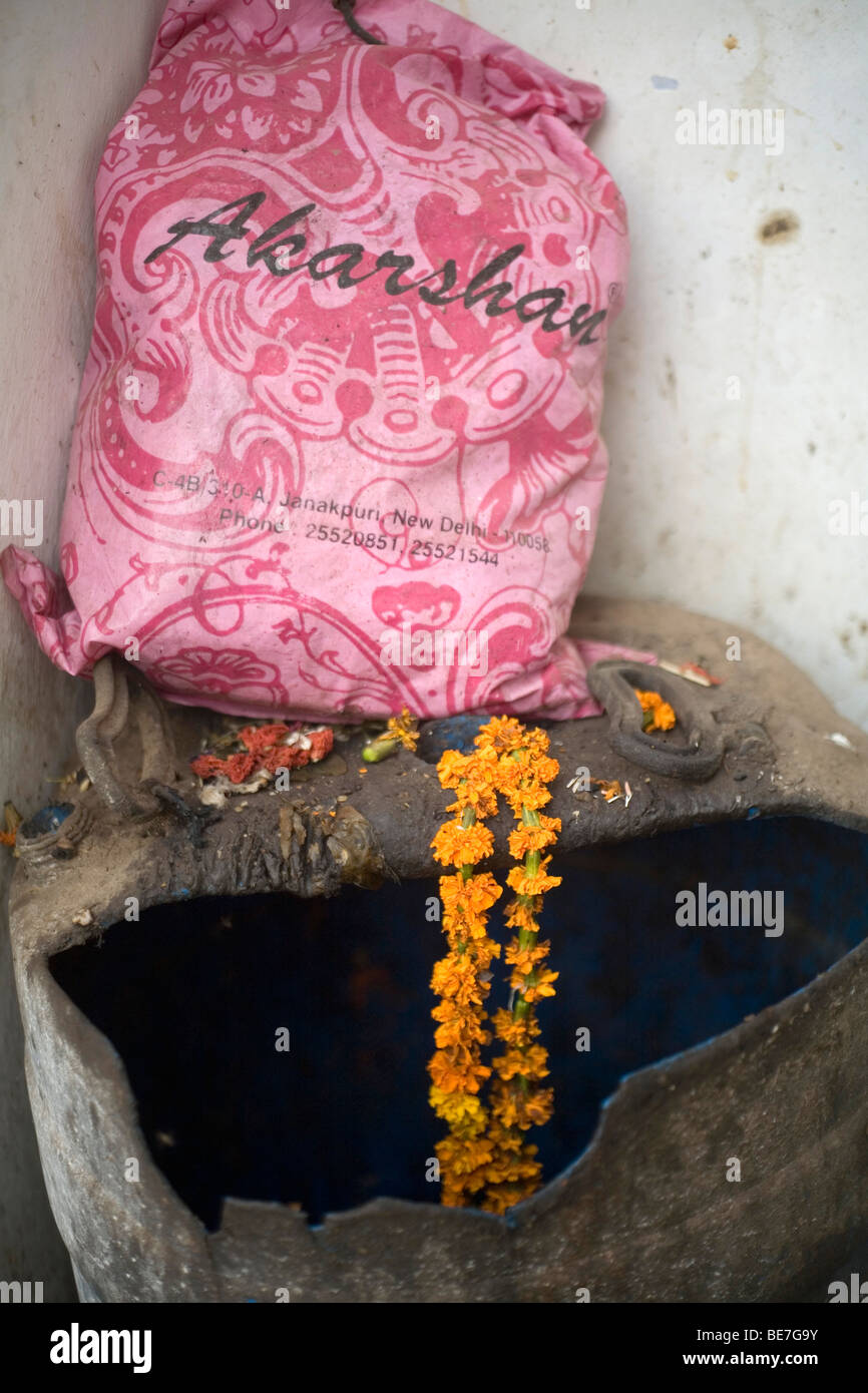 A discarded garland left on a rubbish bin in a Hindu temple Janakpuri, New Delhi, India Stock Photo