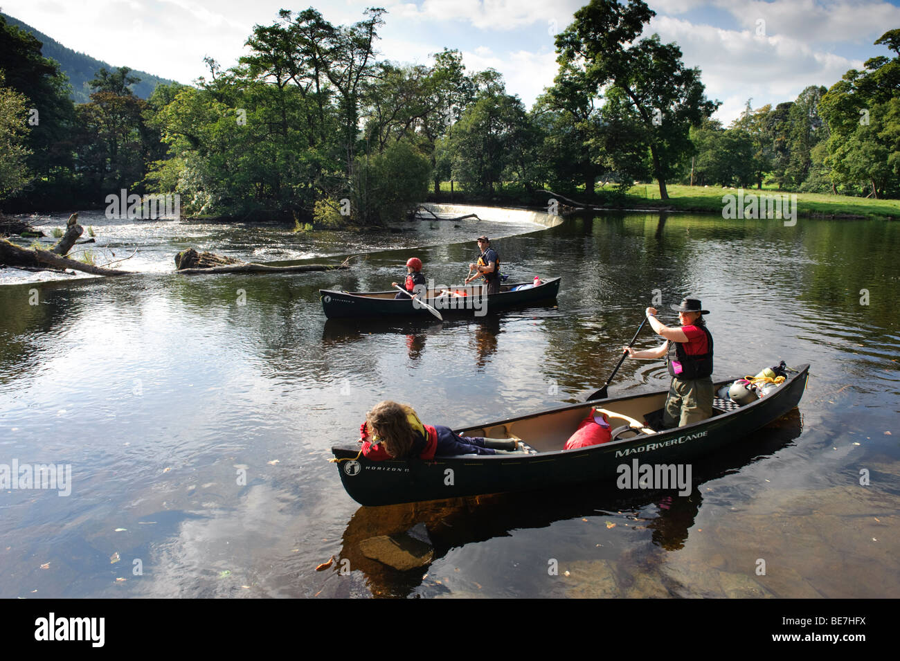 Summer afternoon a family paddling in two open kayaks near the