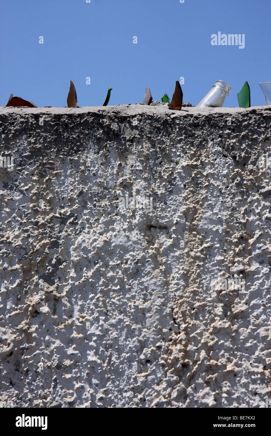 Top of a wall with sharp glass fragments from broken bottles as protection against people climbing over the wall, Nicosia Cyprus Stock Photo