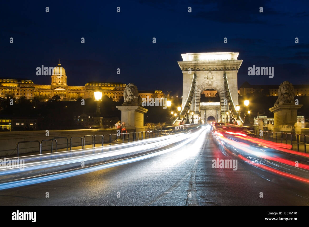 Busy evening traffic crossing Budapest's Chain Bridge with the Royal Palace in the background Stock Photo