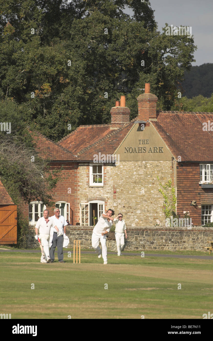 Lurgashall village green sees players participating in a game of cricket on a warm sunny autumn day. Stock Photo