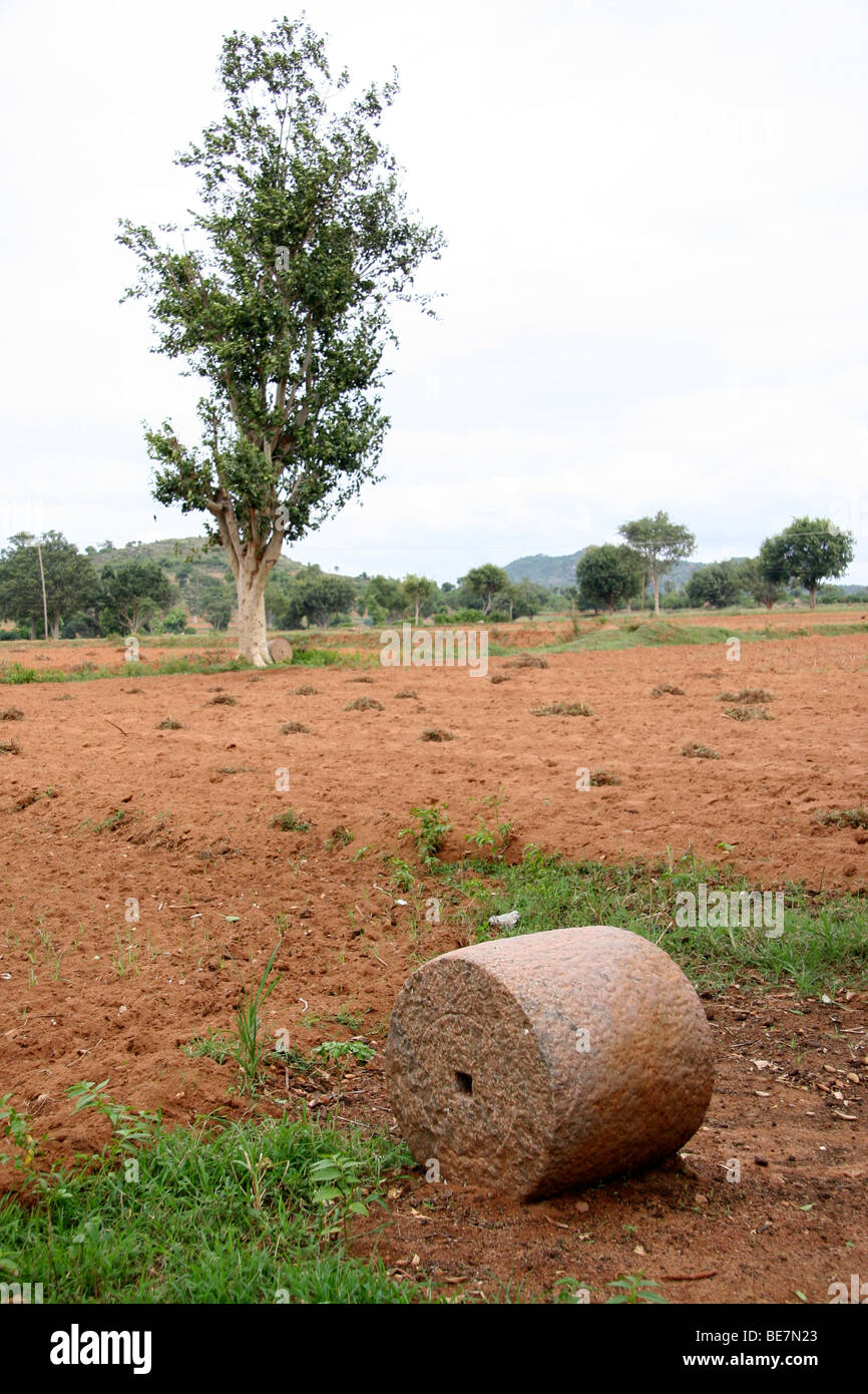A stone roller stands in a field in rural Karnataka in South India. The