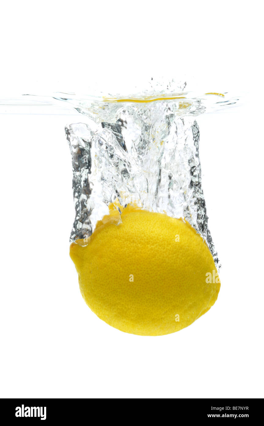Lemon falling into water isolated against a white background Stock Photo
