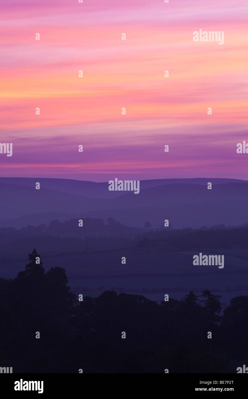An evening view from Chillingham in Northumberland over fields and woodland towards the Cheviot Hills. England, United Kingdom Stock Photo