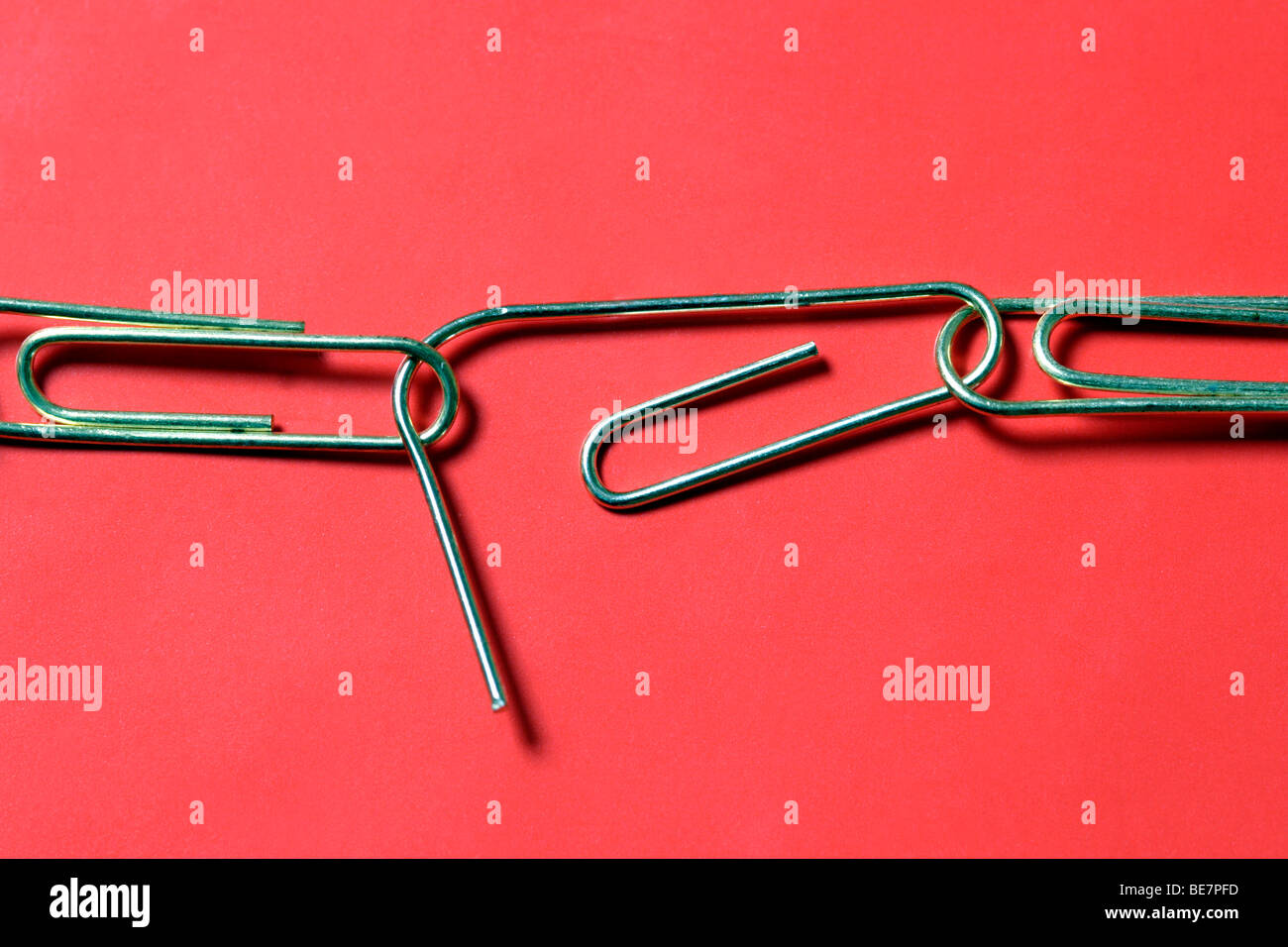 Weakened paperclip chain about to break close up Stock Photo
