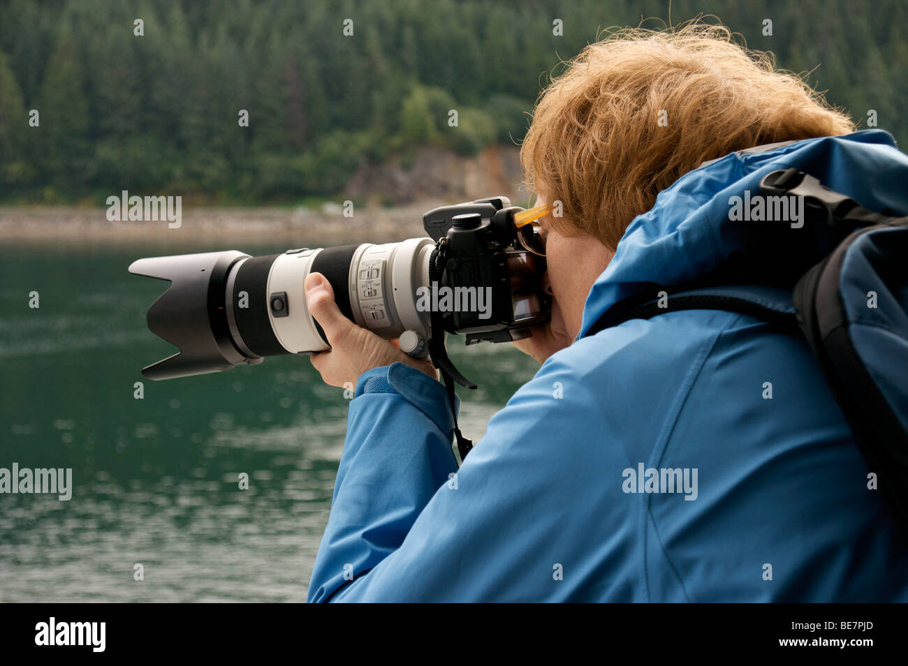 a female photographer shooting with a telephoto lens Stock Photo