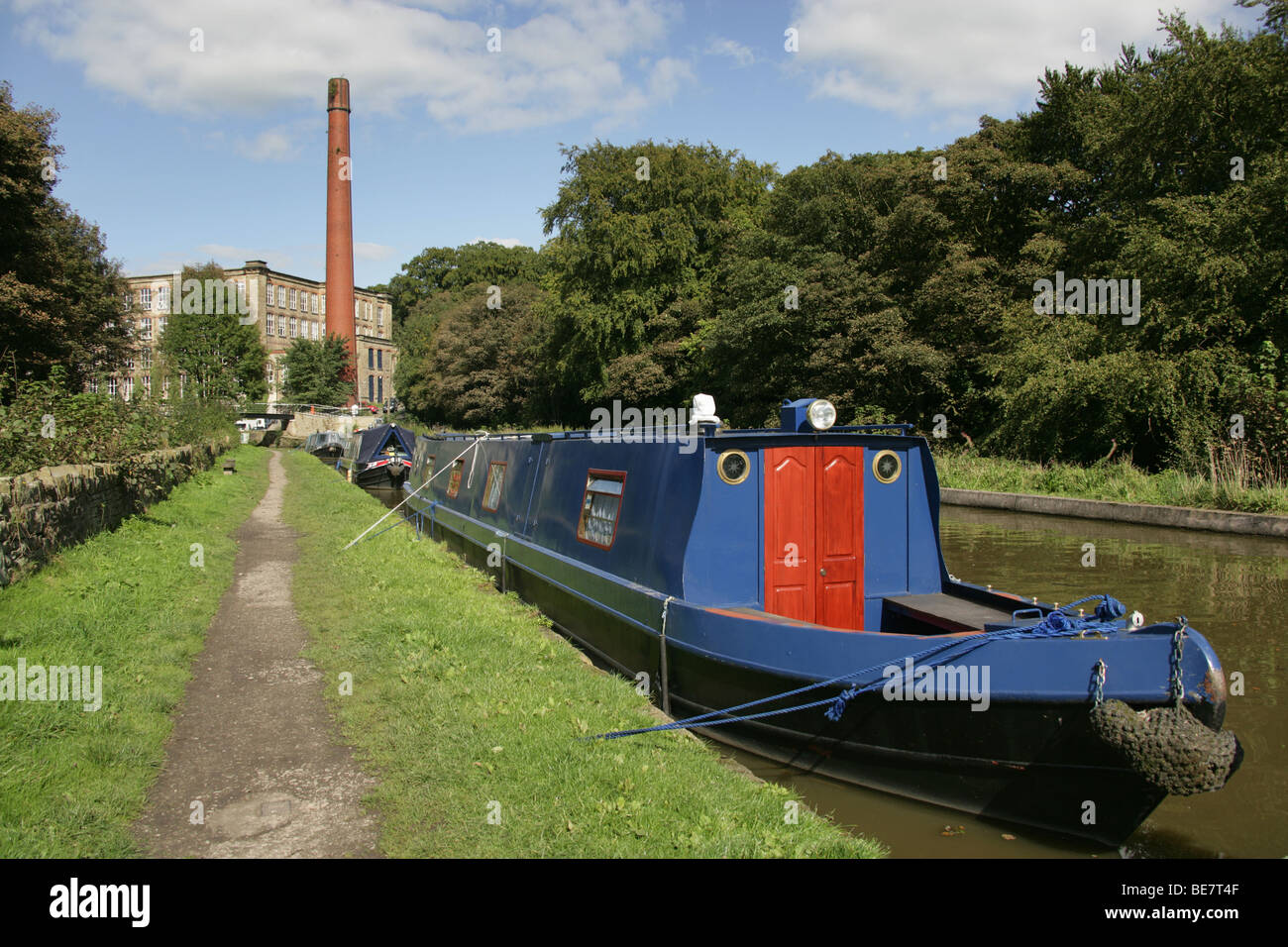 Town of Bollington, England. Canal boats berthed on Macclesfiled Canal at Bollington, with Clarence Mill in the background. Stock Photo