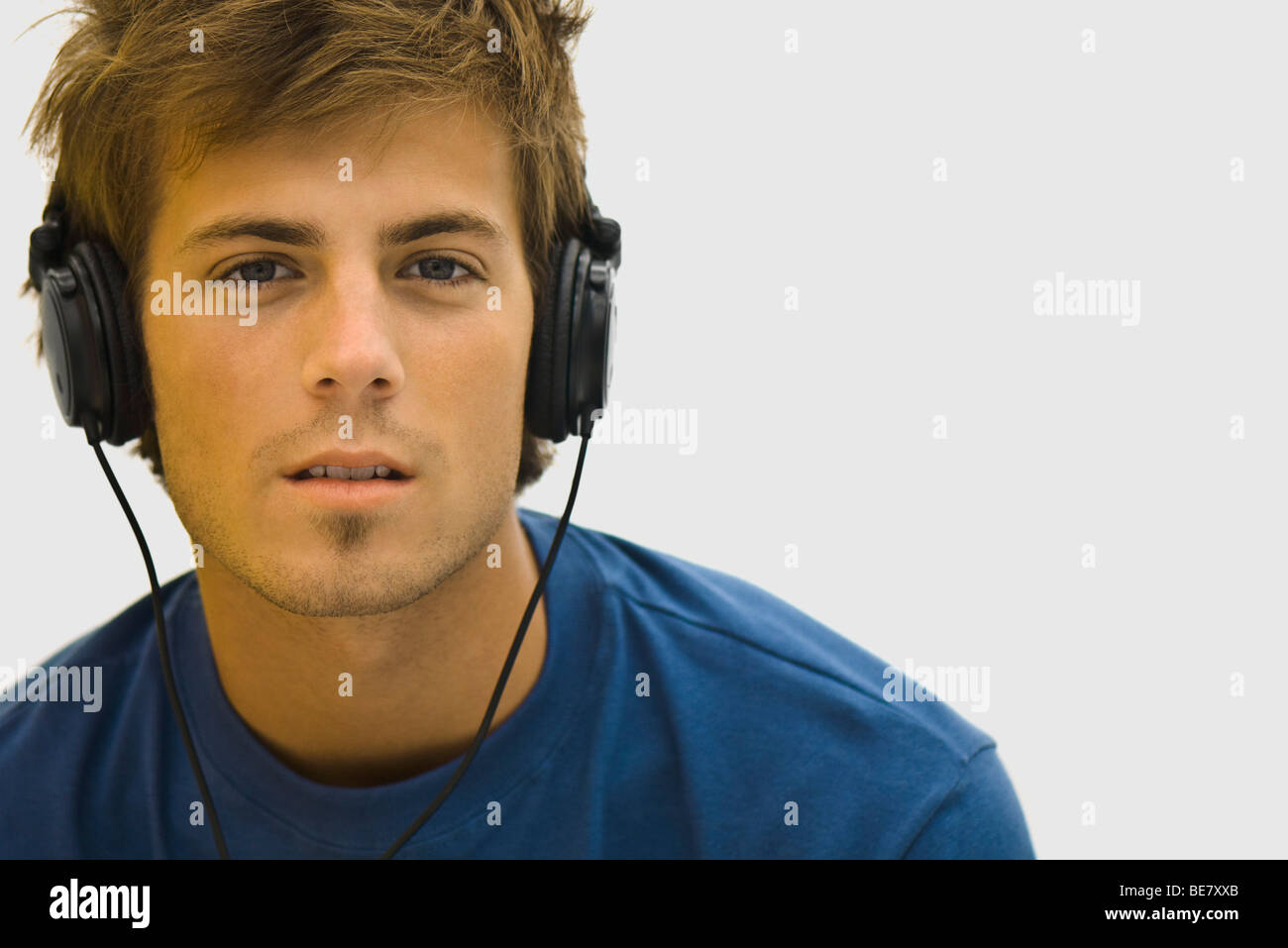 Young man listening to headphones Stock Photo - Alamy