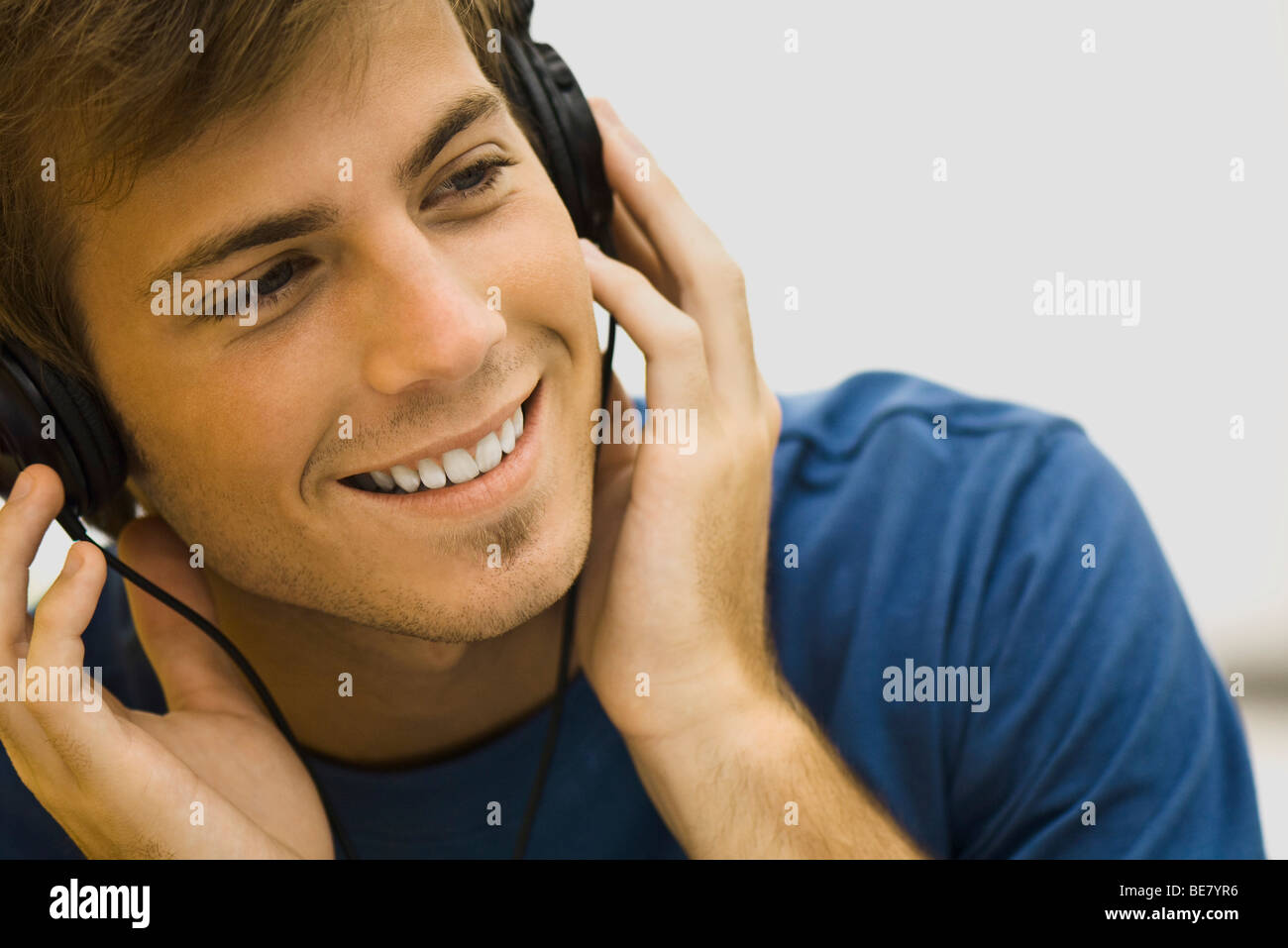 Young man listening to headphones Stock Photo - Alamy