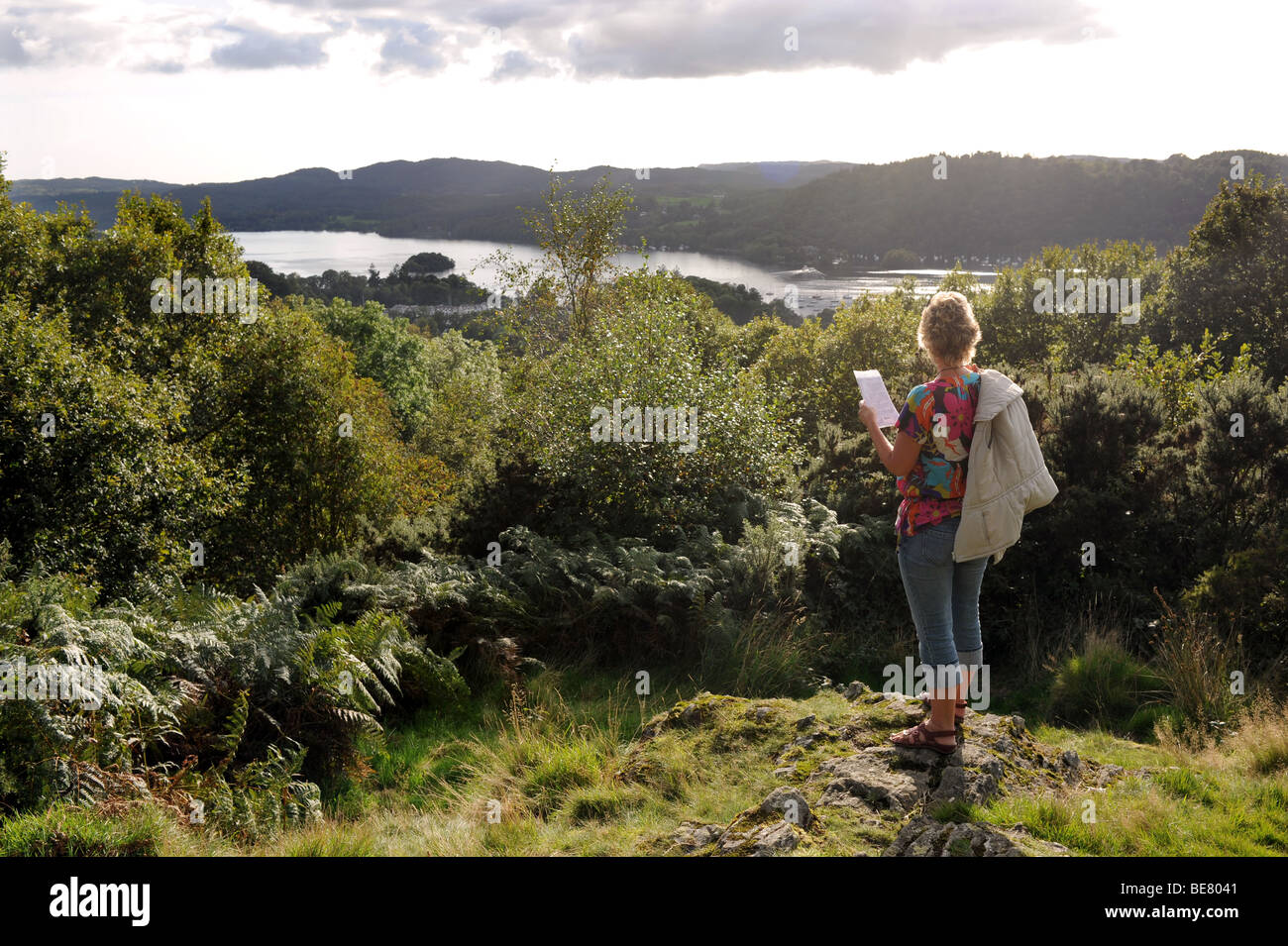 Woman overlooks Lake Windemere from Post Knott above Bowness in The Lake District in Cumbria UK Stock Photo