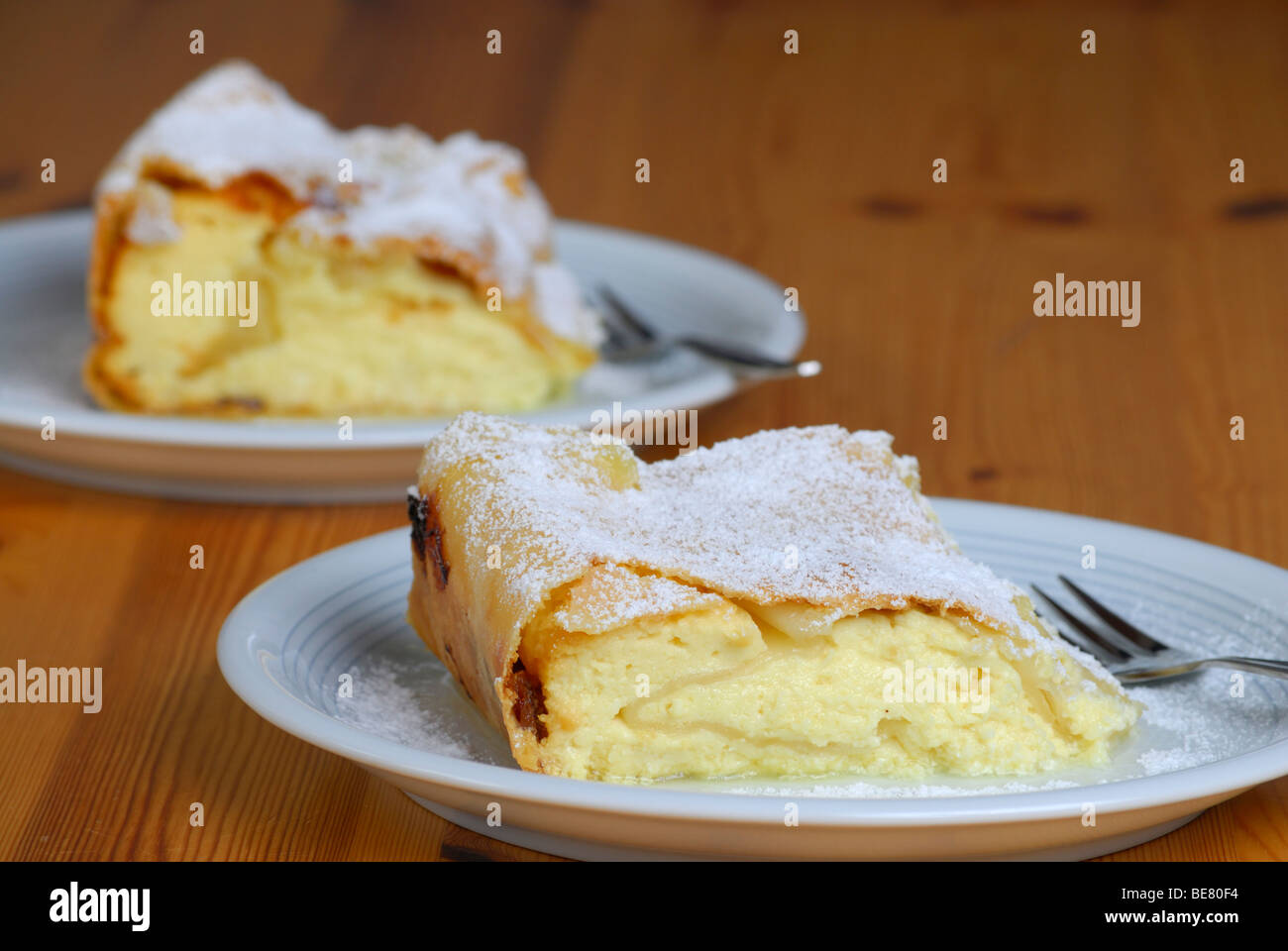 Two portions of quark strudel on plate and wooden table Stock Photo