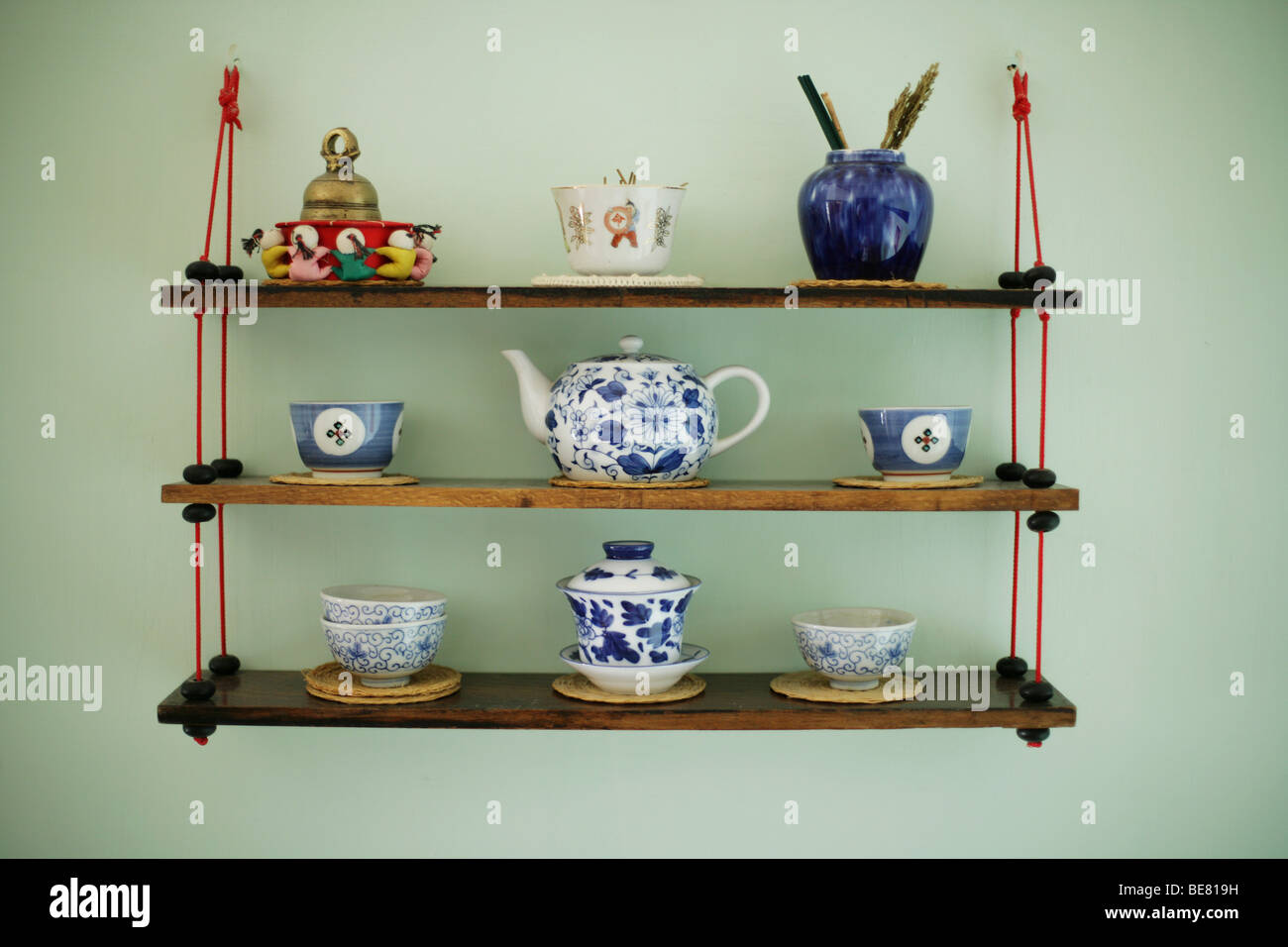 Decorated souvenir shelf with antique asian teapot, cups Stock Photo
