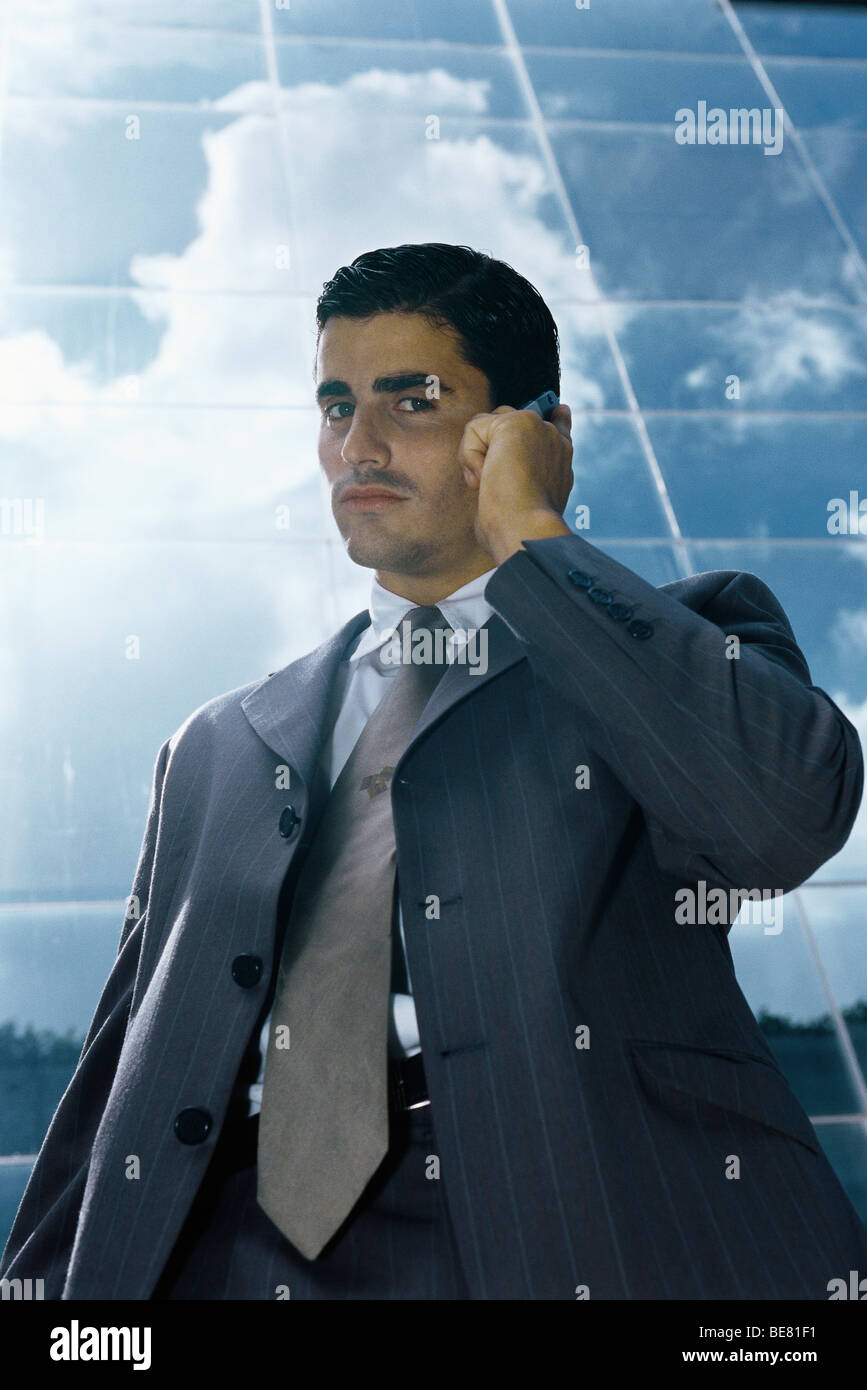 Businessman using cell phone outside office building Stock Photo