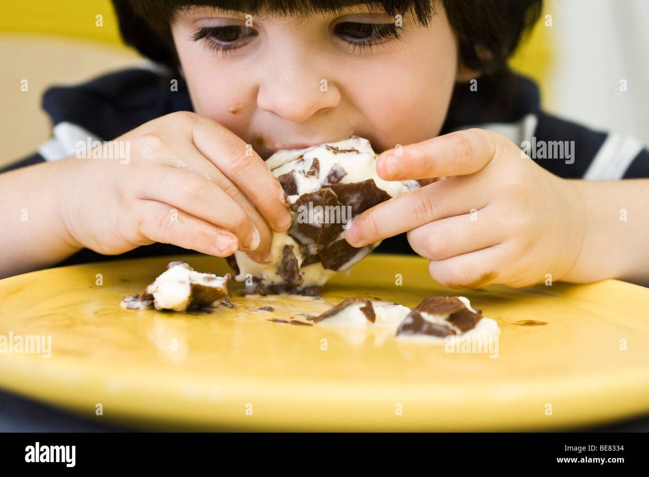 Little boy eating messy ice cream bar Stock Photo
