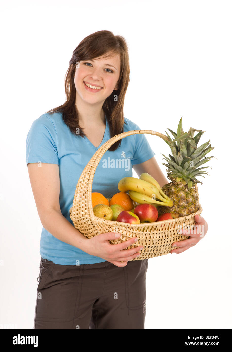 Young woman with fruit basket, smiling Stock Photo - Alamy
