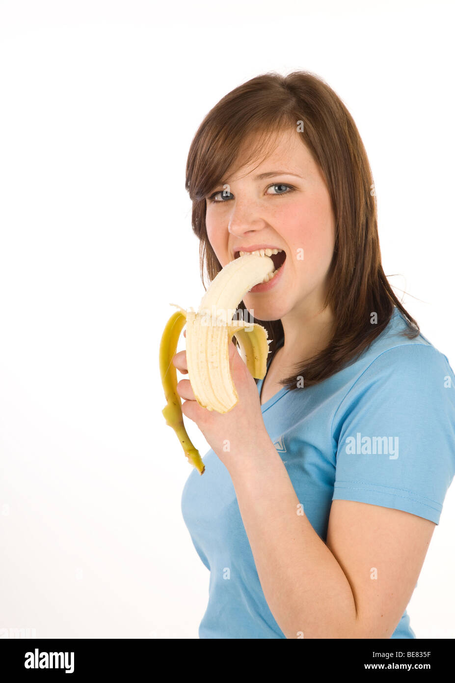 Young woman biting into a banana Stock Photo