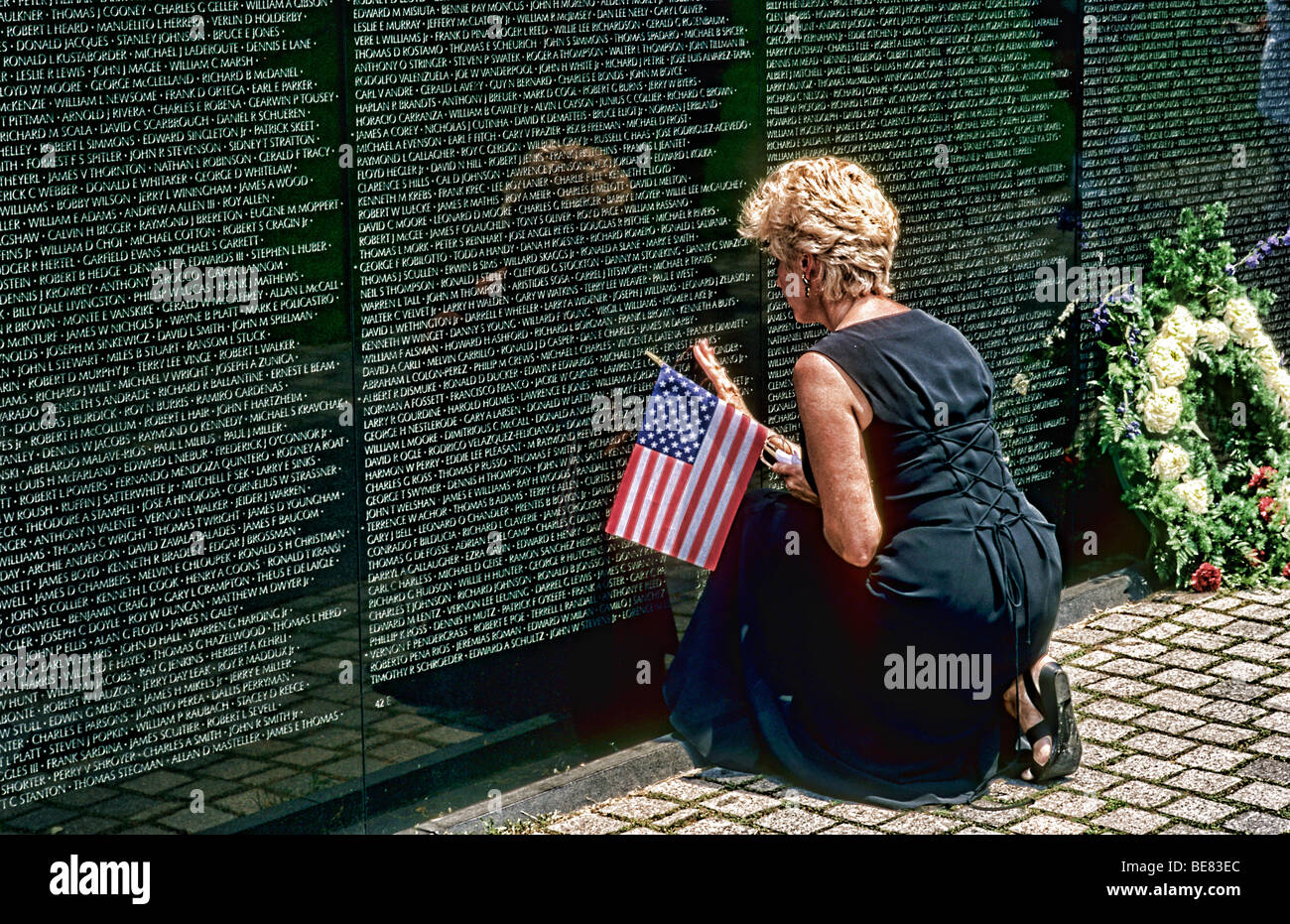 Horizontal shot of widow mourning at the Vietnam Memorial Wall in Washington DC near her loved one Stock Photo