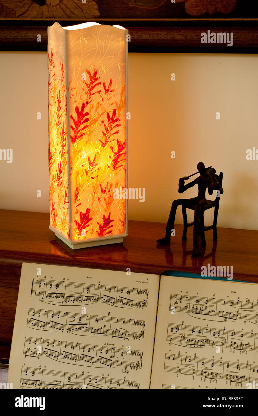 Atmospheric image of a lantern above a piano with open music sheet Stock Photo