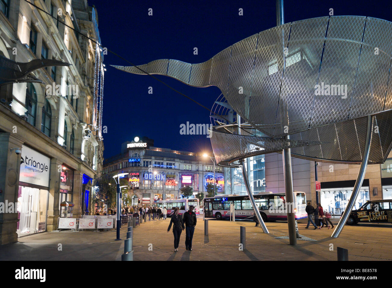 Exchange Square at night  with the 'Arbor' Sculpture by Mel Chantrey in the foreground, City Centre, Manchester, Stock Photo