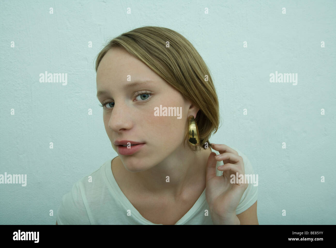 Teen girl wearing large hoop earring, looking at camera Stock Photo