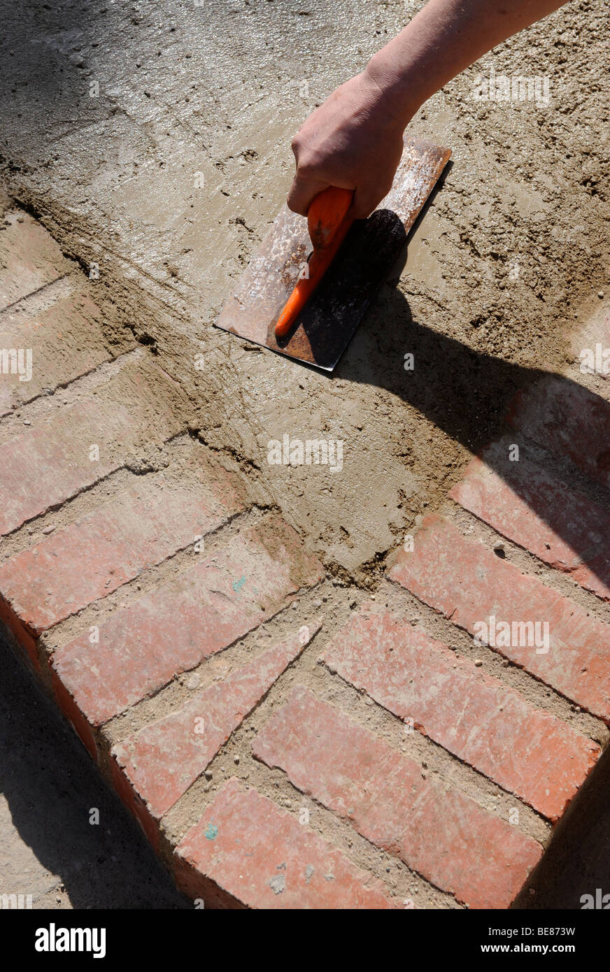 DETAIL OF SMOOTHING CONCRETE WITH A BUILDERS FOAT IN CONSTRUCTION OF A