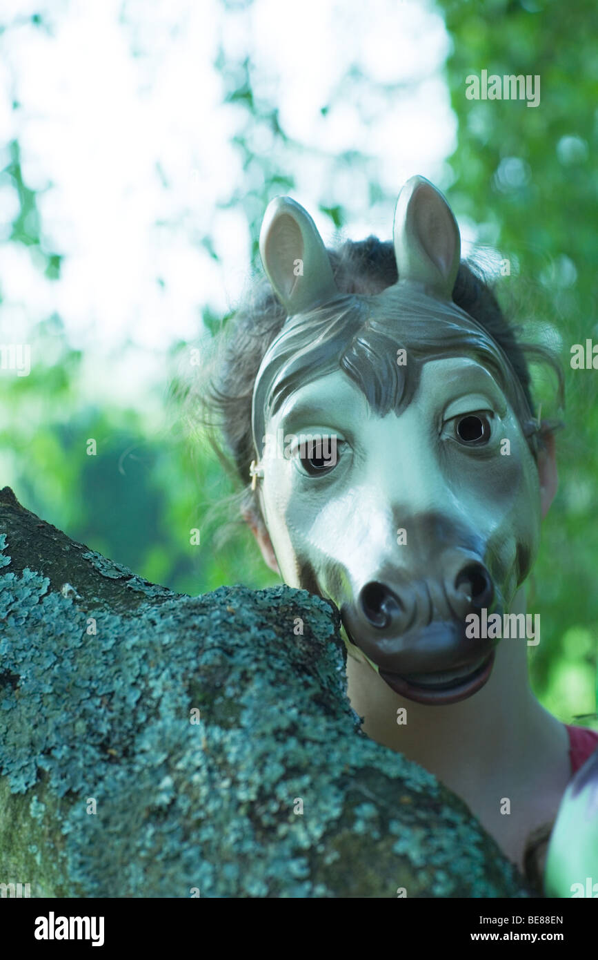 Person wearing horse mask outdoors, portrait Stock Photo