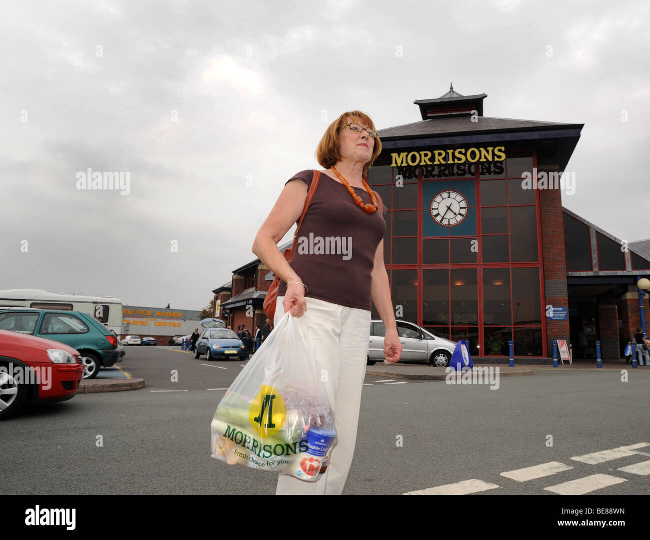 Middle aged woman shopper leaving Morrisons supermarket Wellington Shropshire England Uk Stock Photo