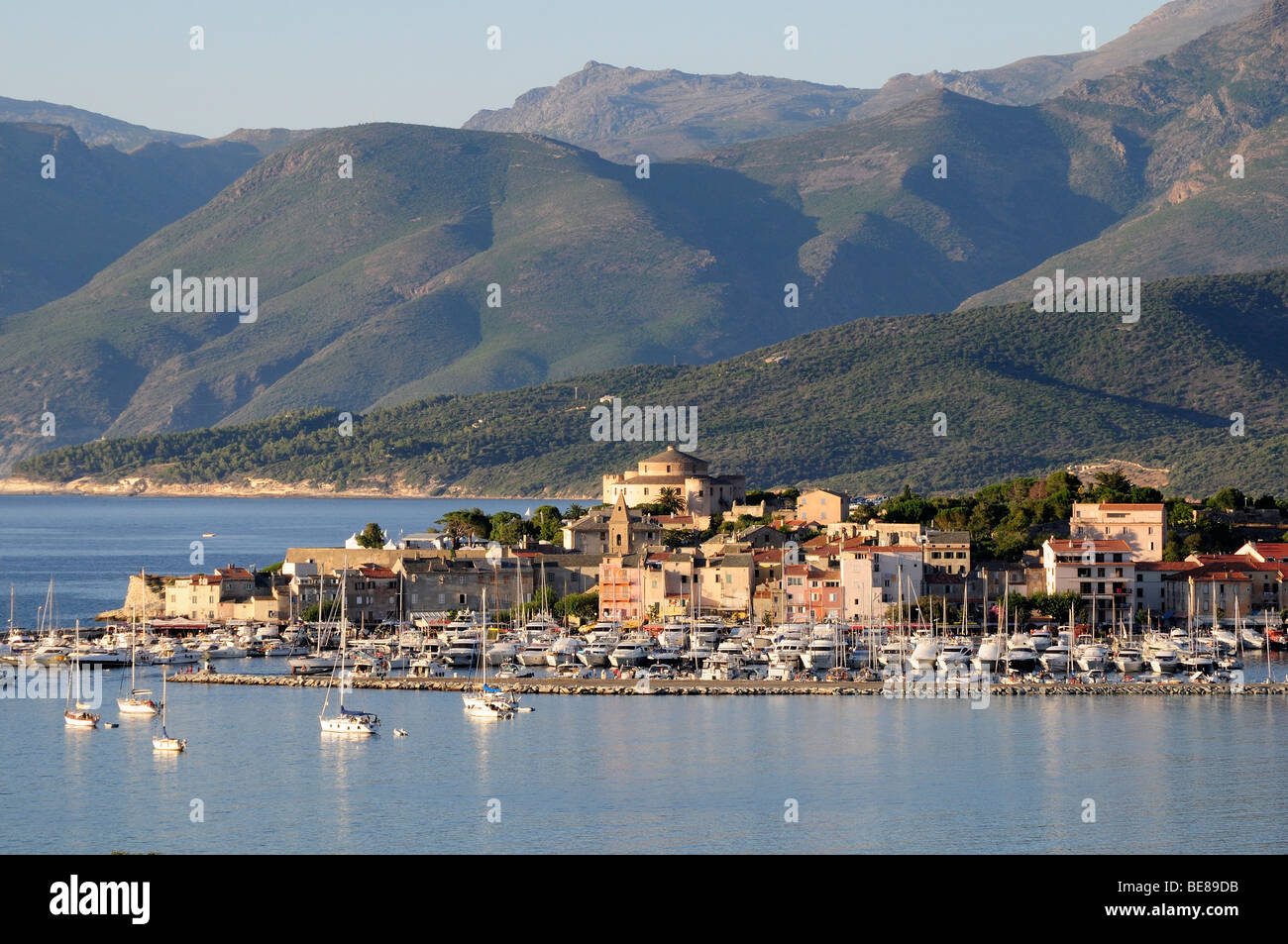 FRANCE Mediterranean Corsica St Florent View of Old Town and  harbour with yachts moored situated at the base of mountains. Stock Photo