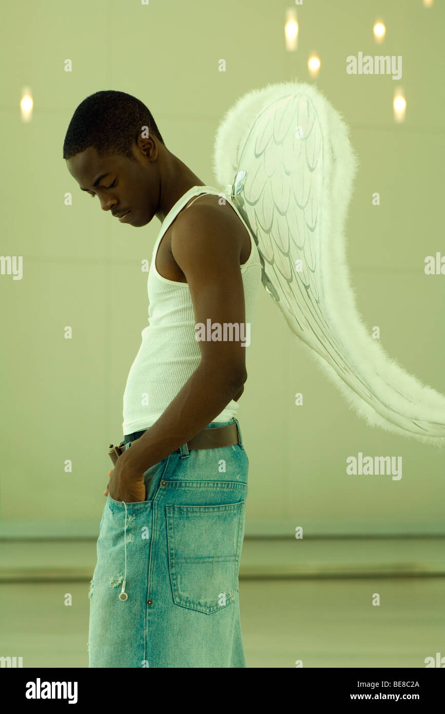 Male wearing angel wings, hands in pockets, head down Stock Photo Alamy