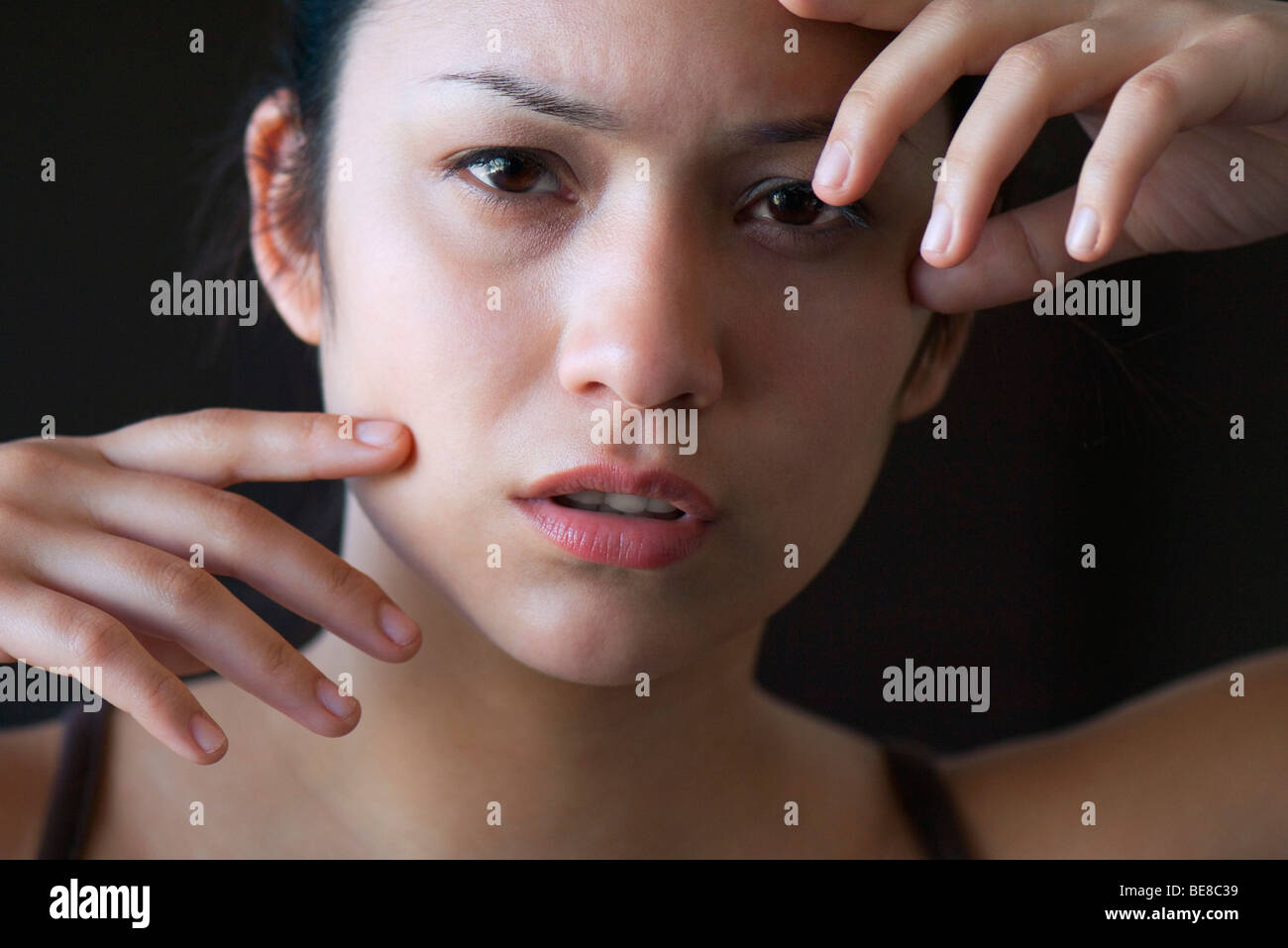 Woman with look of distress, hand's raised Stock Photo