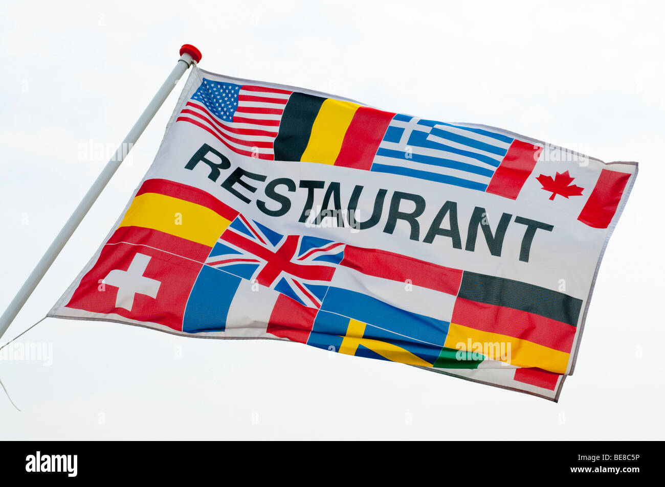 A Banner With Various Flags Blows In Front Of A Restaurant At The