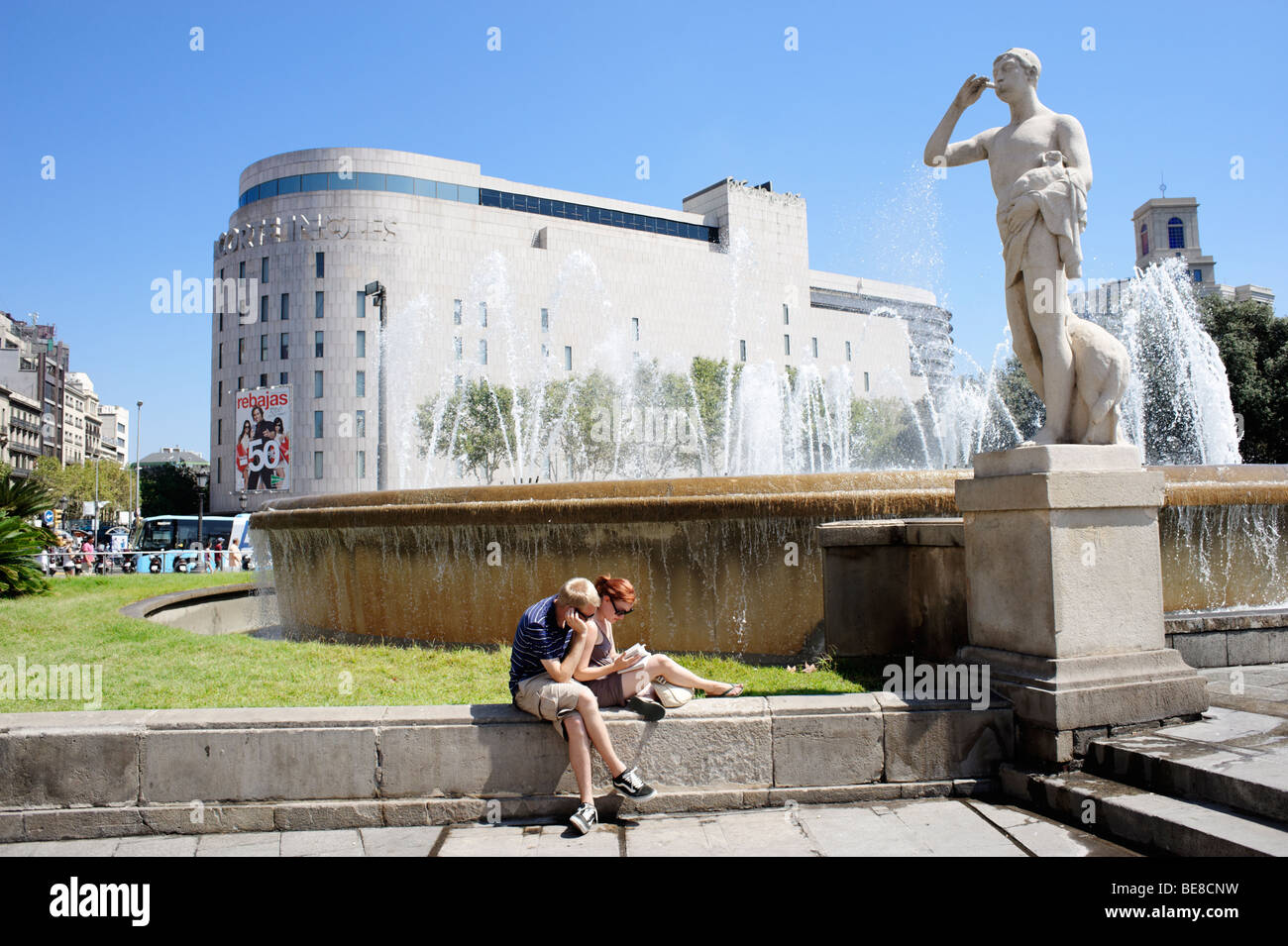 Tourists sitting in front of El Corte Ingles department store. Plaza Catalunya. Barcelona. Spain Stock Photo