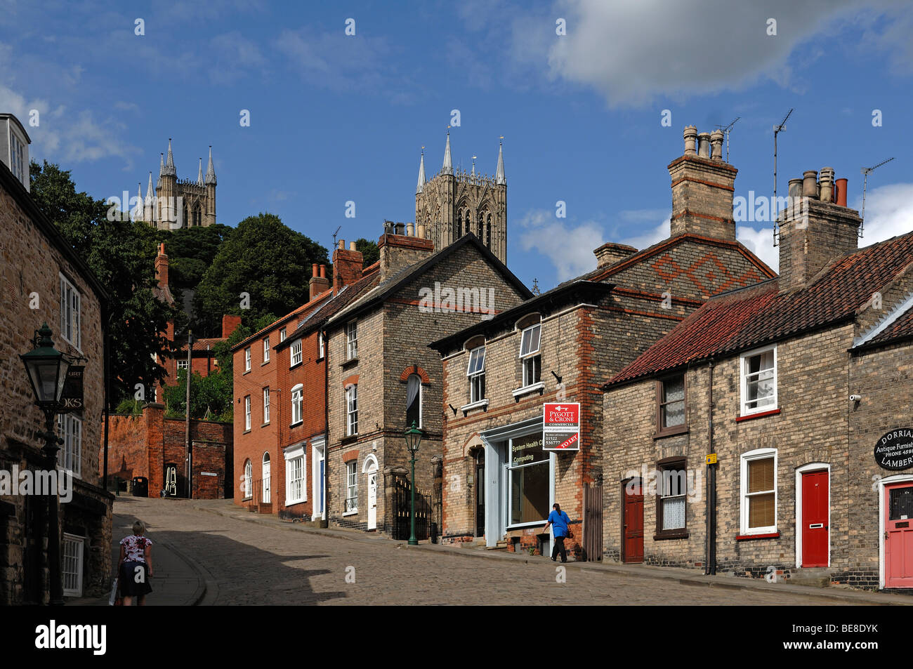 Old houses on a mountain road, Steep Hill, in front of the towers of Lincoln Cathedral, Lincoln, Lincolnshire, England, United  Stock Photo