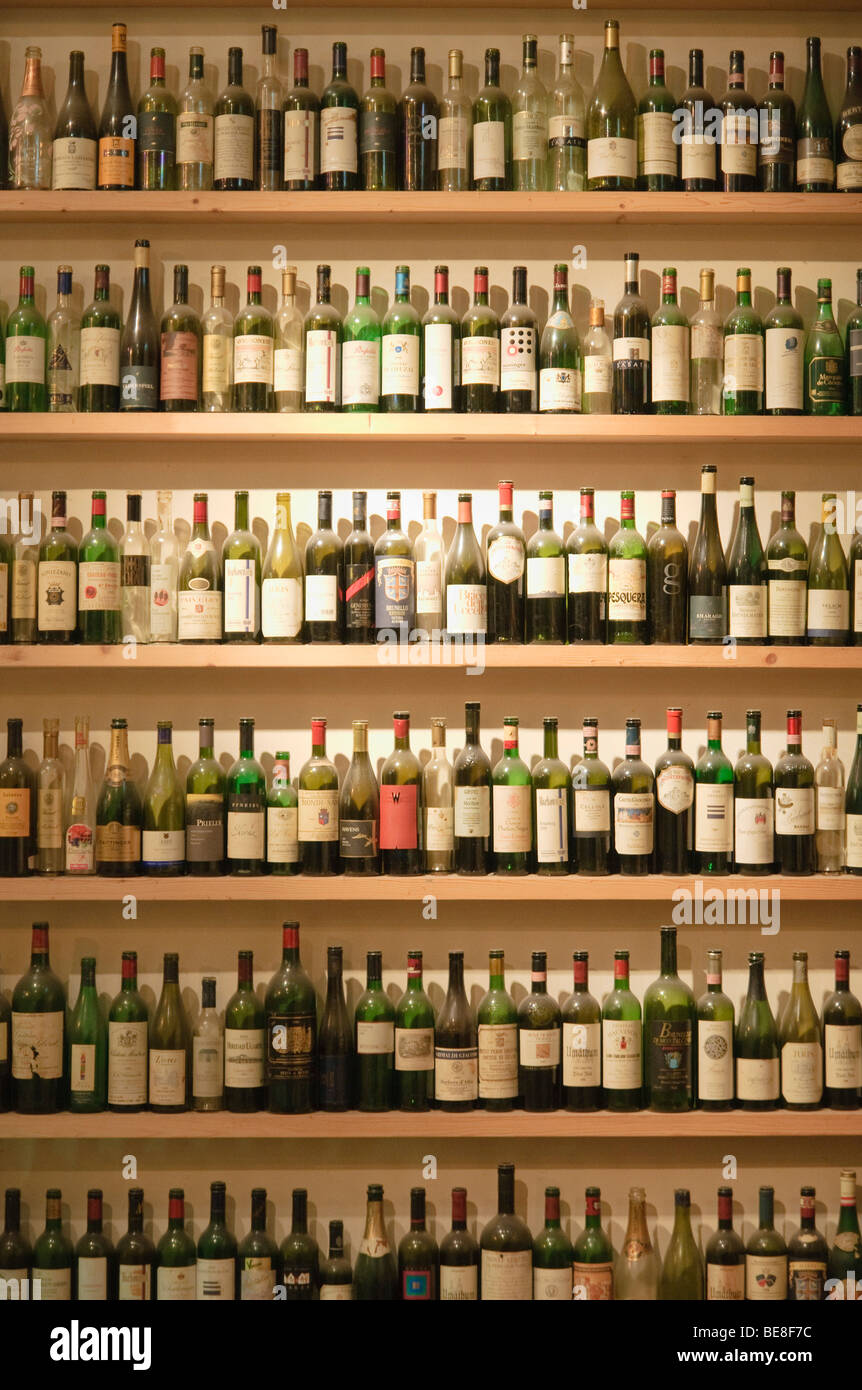 Many empty wine bottles on the shelves in the window of a wine