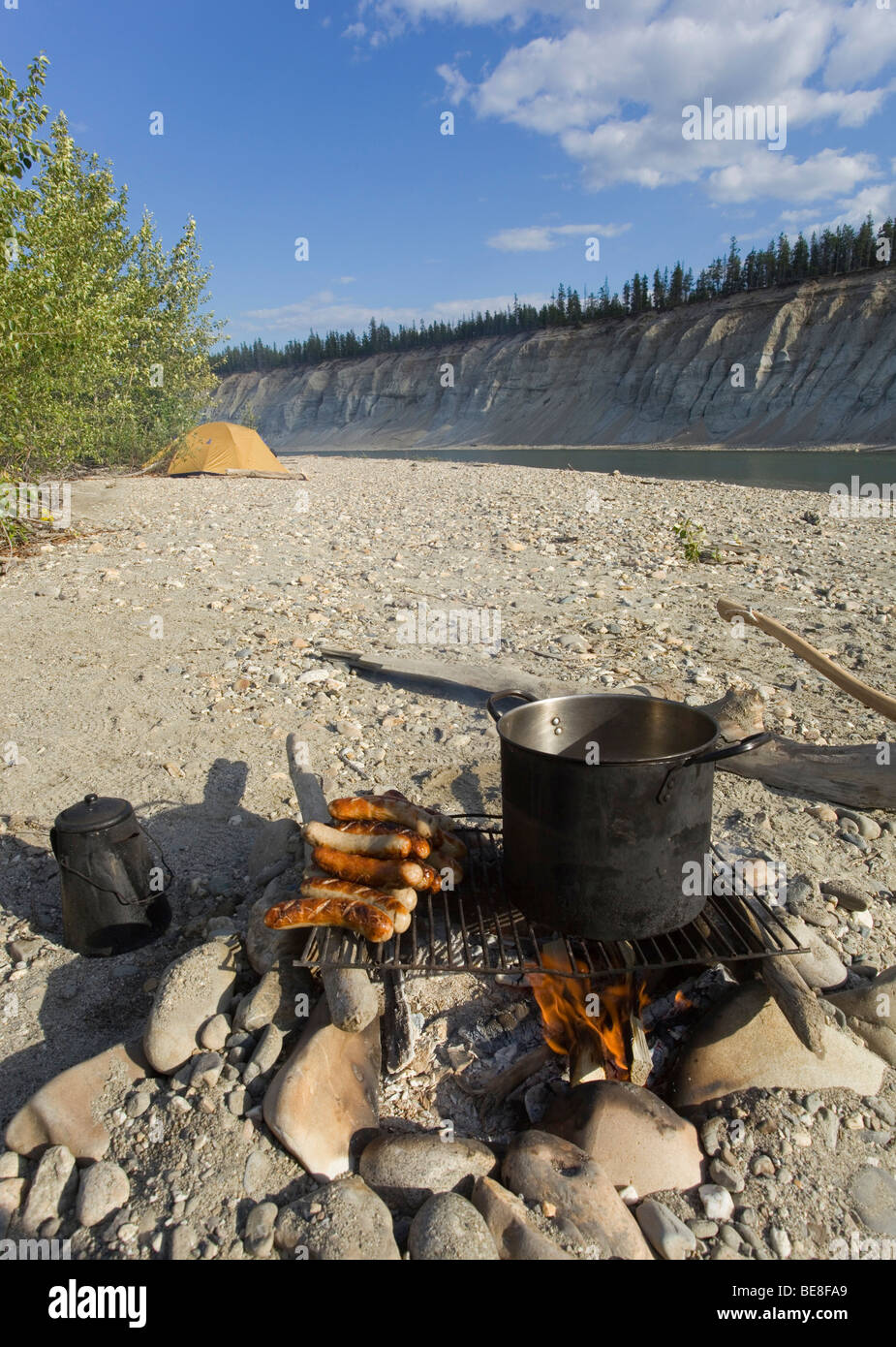 Cooking on a campfire, BBQ sausages, bratwurst, kettle, pot, grill, upper Liard River, Yukon Territory, Canada Stock Photo