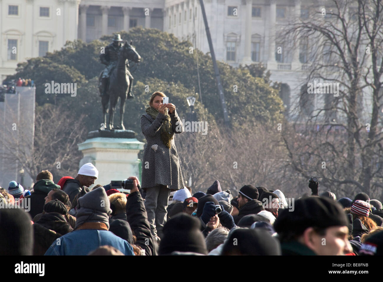 Woman standing above crowd taking photograph. Inauguration Day 2009. Washington DC Stock Photo