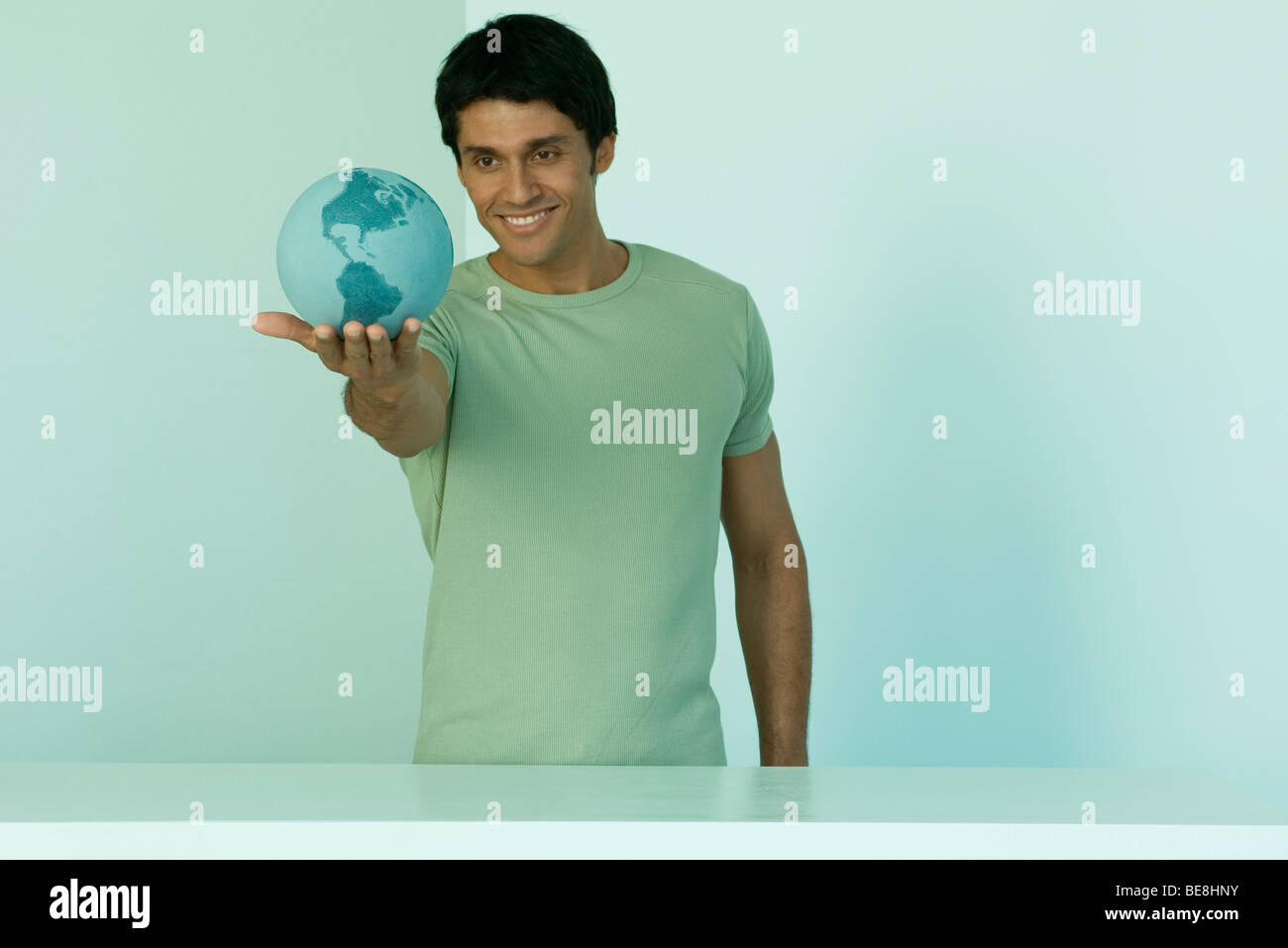 Man holding globe in palm of hand Stock Photo - Alamy