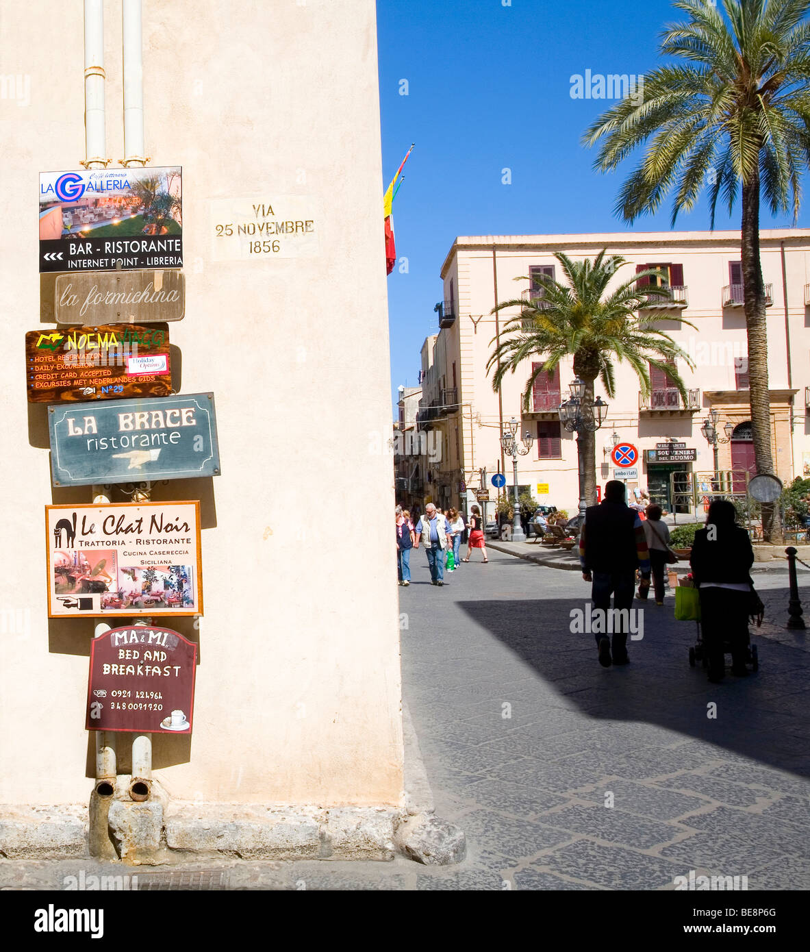 Signs on Via 25 Novembre, a busy street in the town of Cefalu on the island of Sicily, Italy Stock Photo